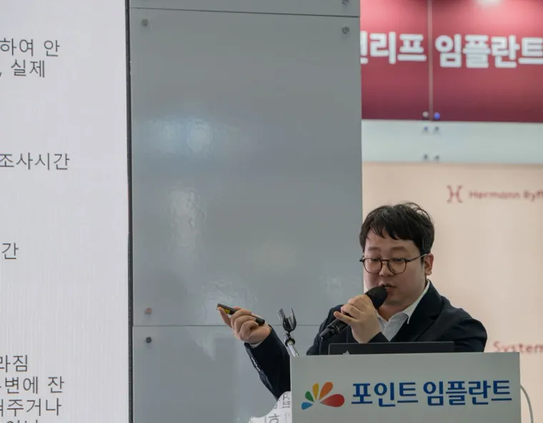 포인트 임플란트 연단에서 마이크를 잡고 설명하는 김교락 대표원장